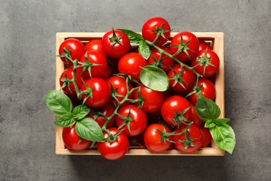 Crate with fresh cherry tomatoes on stone background, top view