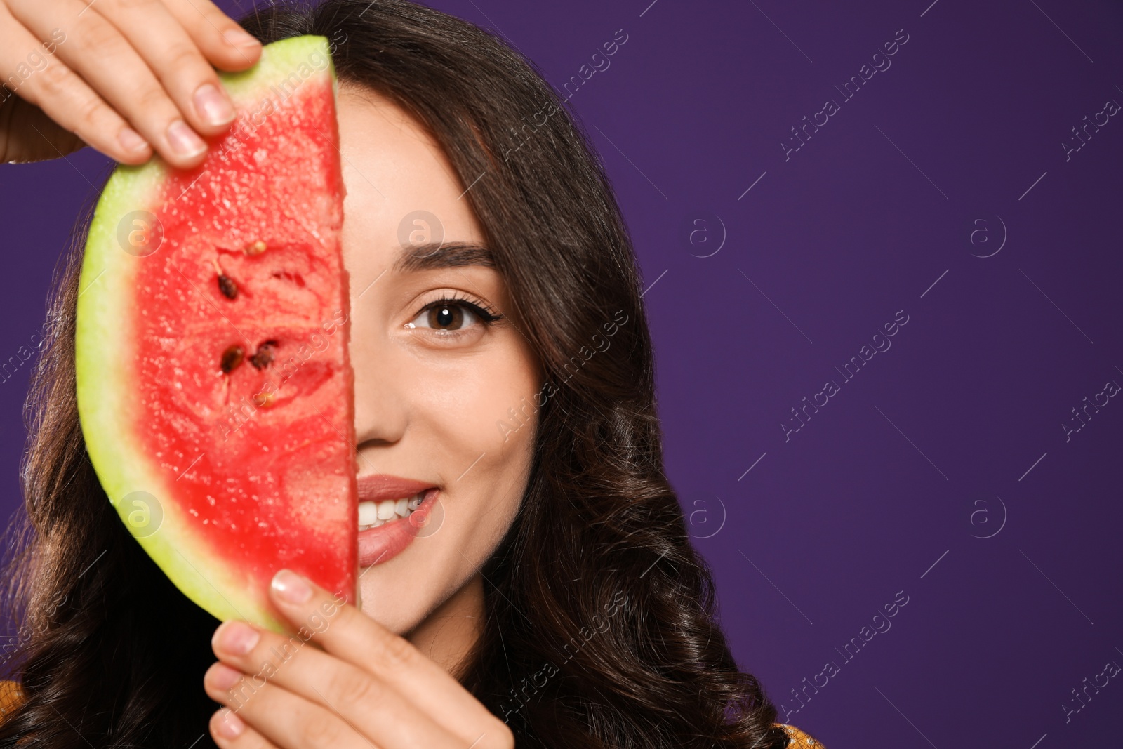 Photo of Beautiful young woman with watermelon on purple background. Space for text