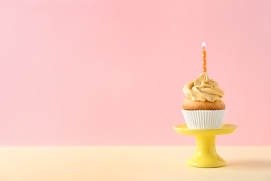 Dessert stand with delicious birthday cupcake on color background