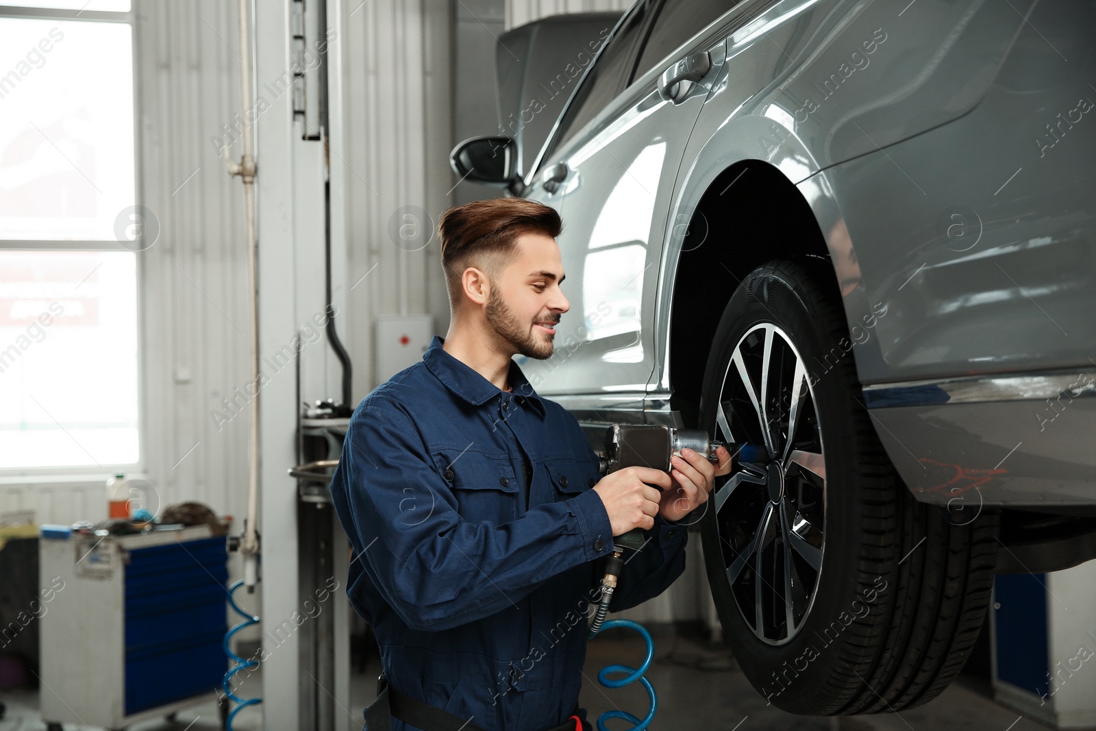 Photo of Technician working with car in automobile repair shop