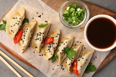 Delicious gyoza (asian dumplings) served on gray table, flat lay