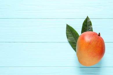 Photo of Flat lay composition with mango on color wooden background. Space for text