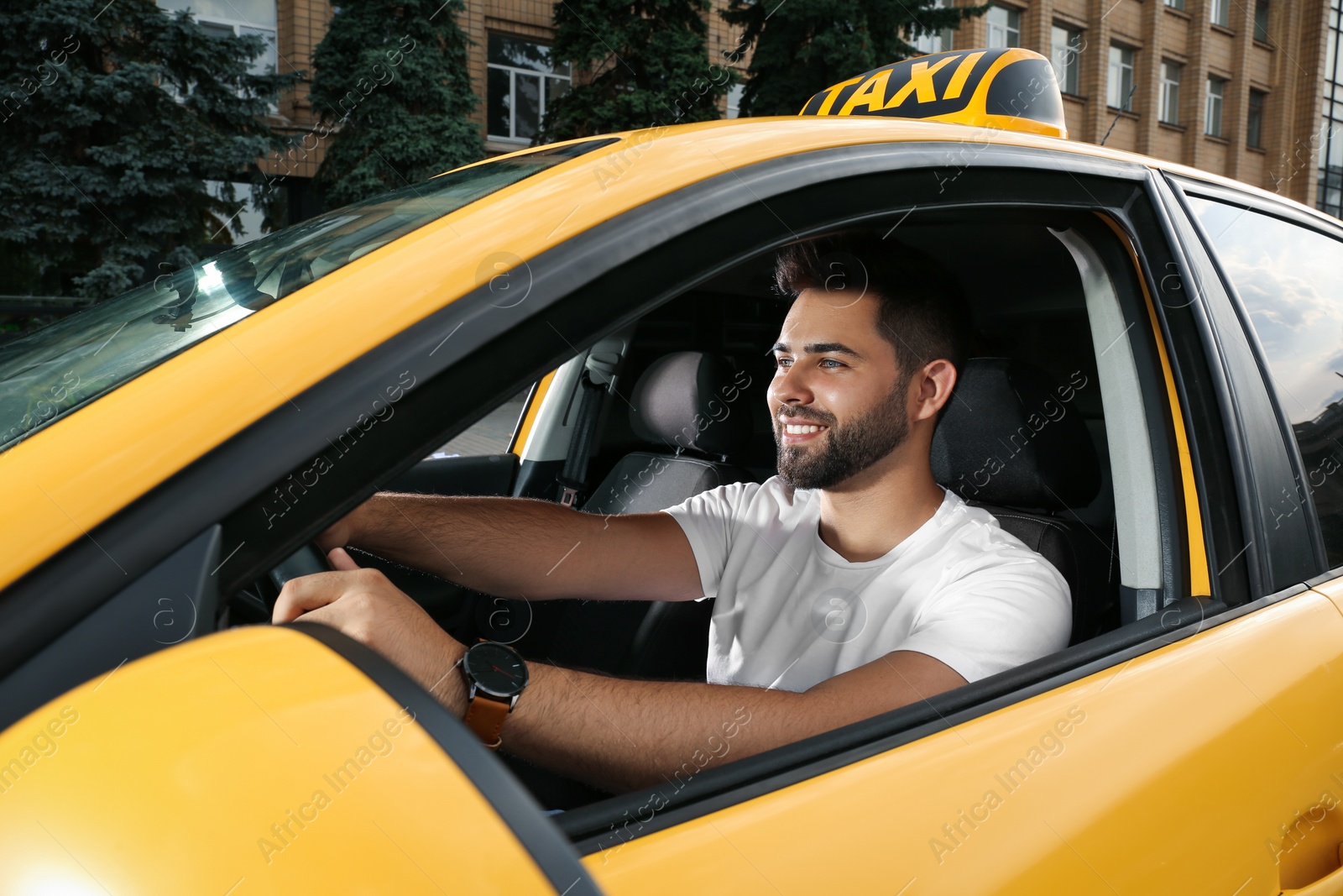 Photo of Handsome taxi driver in car on city street