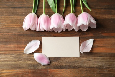 Photo of Tulips and greeting card for Mother's Day on wooden background