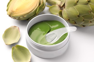 Photo of Package of under eye patches and artichoke on white background. Cosmetic product