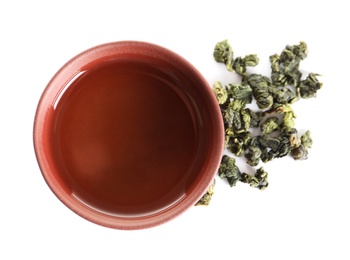Photo of Cup of Tie Guan Yin oolong and tea leaves on white background, top view
