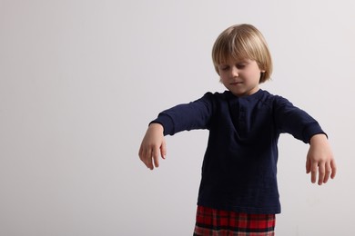 Photo of Boy in pajamas sleepwalking on white background, space for text