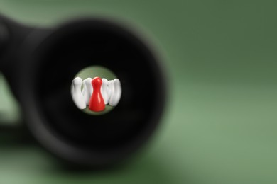 Recruiter searching employee. Red and white pawns visible through binoculars on green background. Space for text