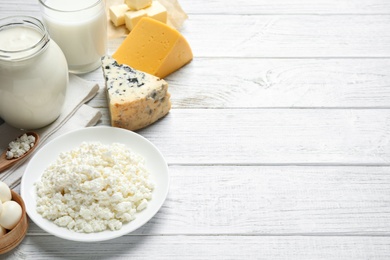 Different dairy products on white wooden table. Space for text