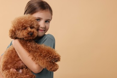 Photo of Little child with cute puppy on beige background, space for text. Lovely pet