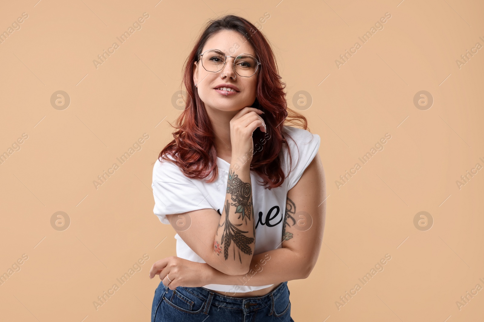 Photo of Portrait of beautiful tattooed woman on beige background