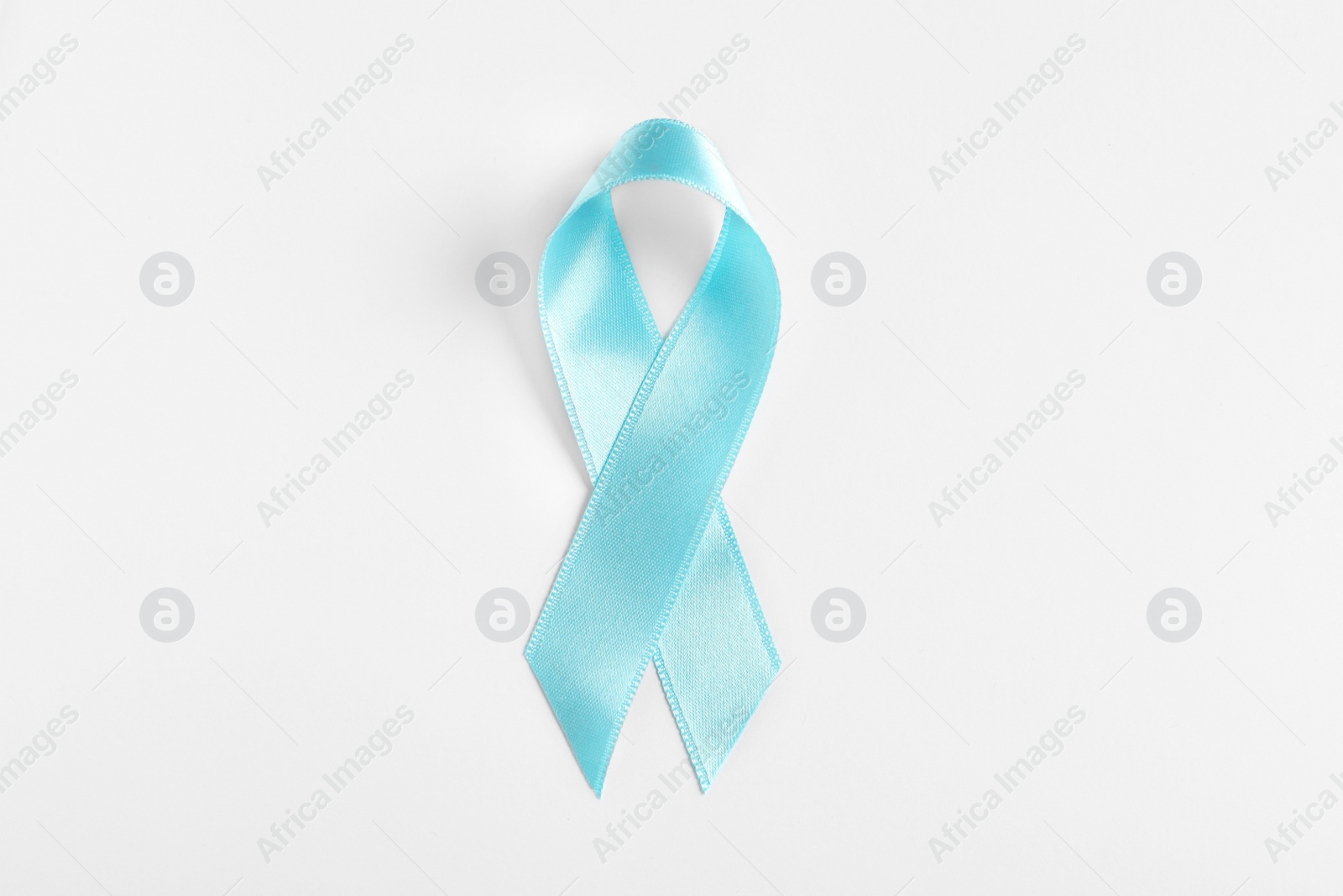 Photo of Blue ribbon on white background, top view. Cancer awareness