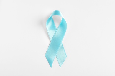 Blue ribbon on white background, top view. Cancer awareness