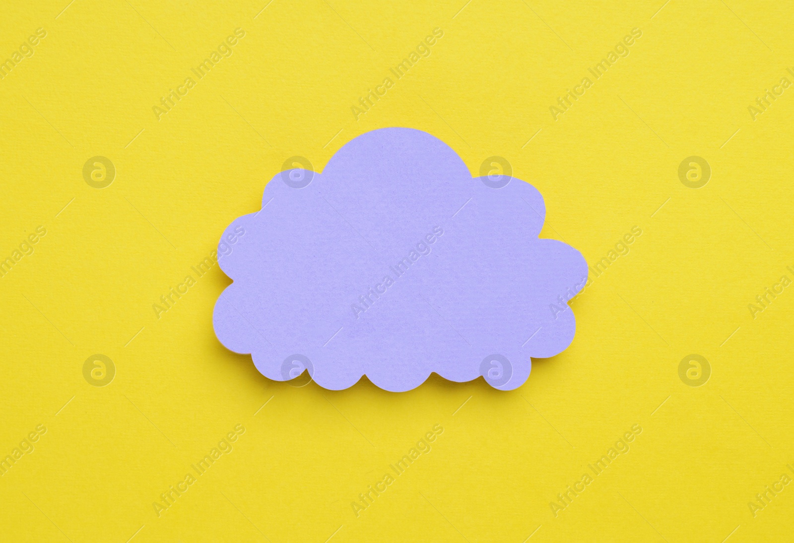Photo of Paper speech bubble in shape of cloud on yellow background, top view. Space for text