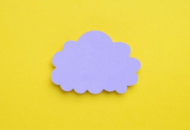 Paper speech bubble in shape of cloud on yellow background, top view. Space for text