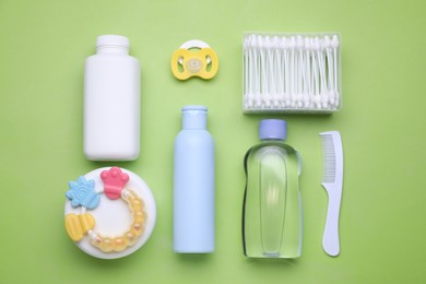 Photo of Flat lay composition with baby care products and accessories on light green background