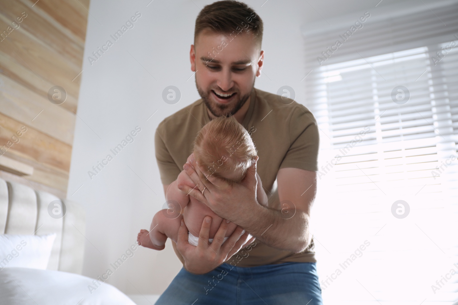 Photo of Father with his newborn son at home