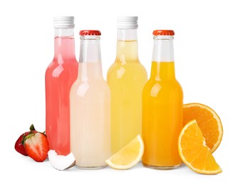 Photo of Delicious kombucha in glass bottles, fresh fruits and coconut isolated on white