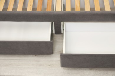 Photo of Storage drawers for bedding under modern bed in room, closeup