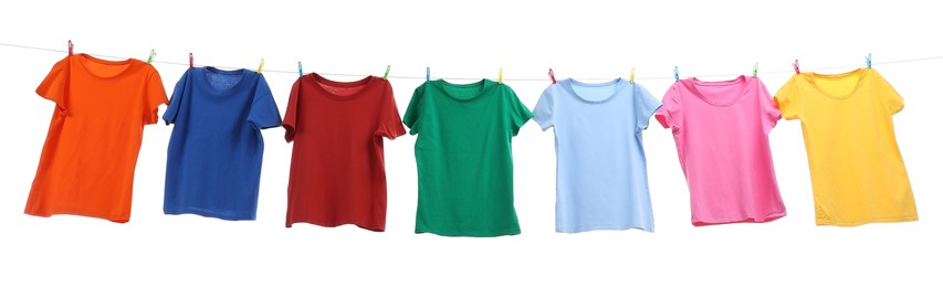 Photo of Colorful t-shirts drying on washing line isolated on white