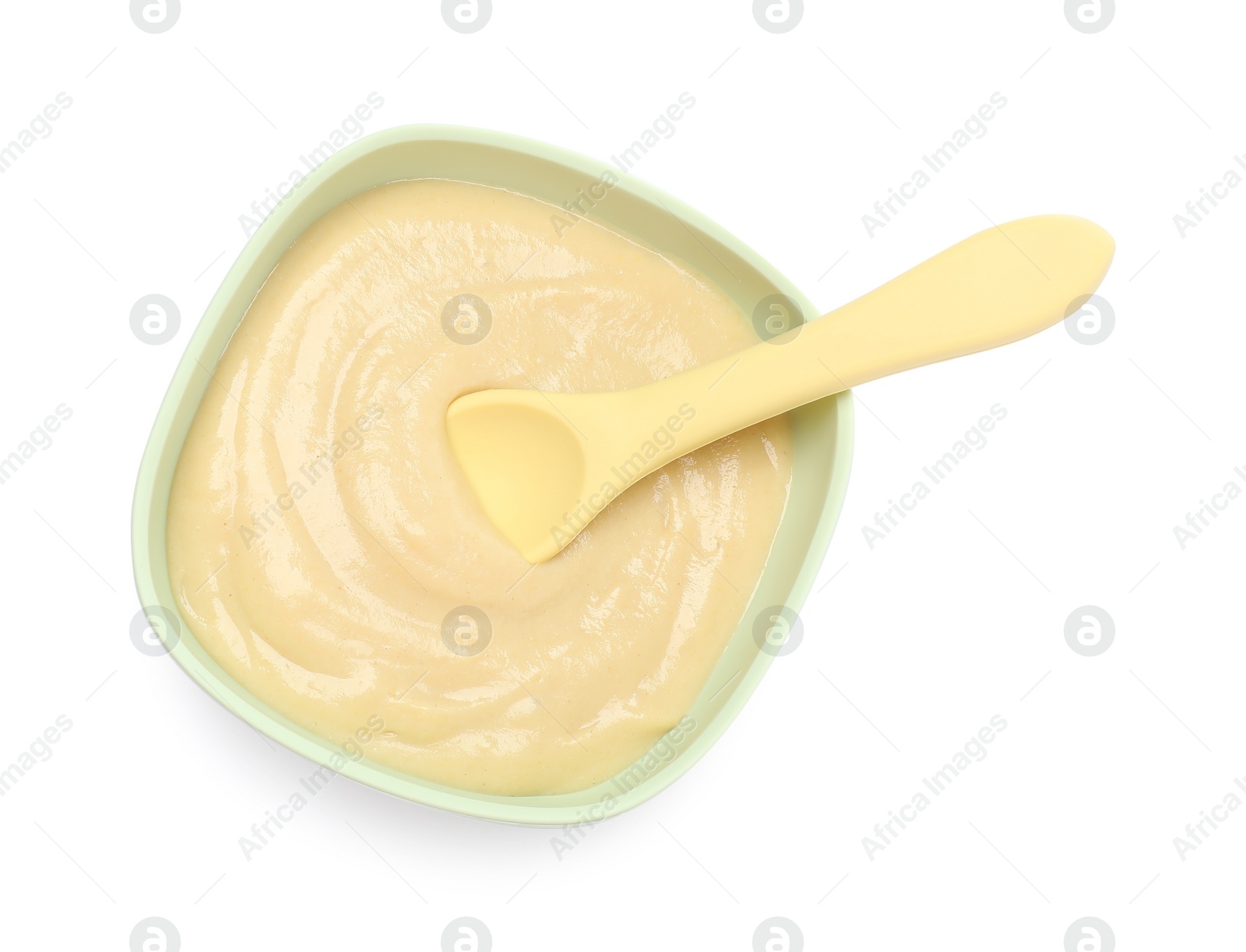 Photo of Tasty baby food and spoon in bowl isolated on white, top view