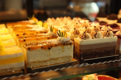 Photo of Different delicious cakes on counter in bakery shop, closeup