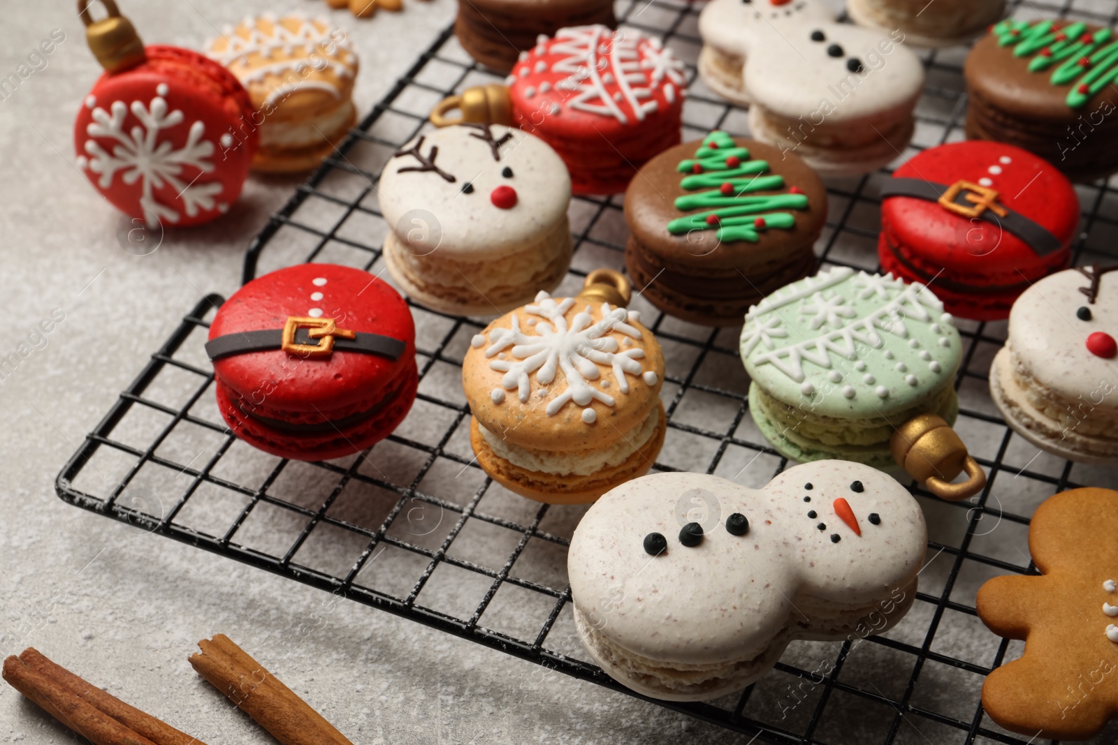 Photo of Beautifully decorated Christmas macarons on light grey table, closeup