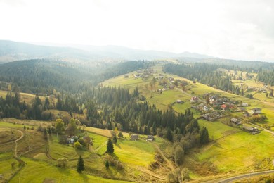 Aerial view of beautiful forest and mountain village on autumn day