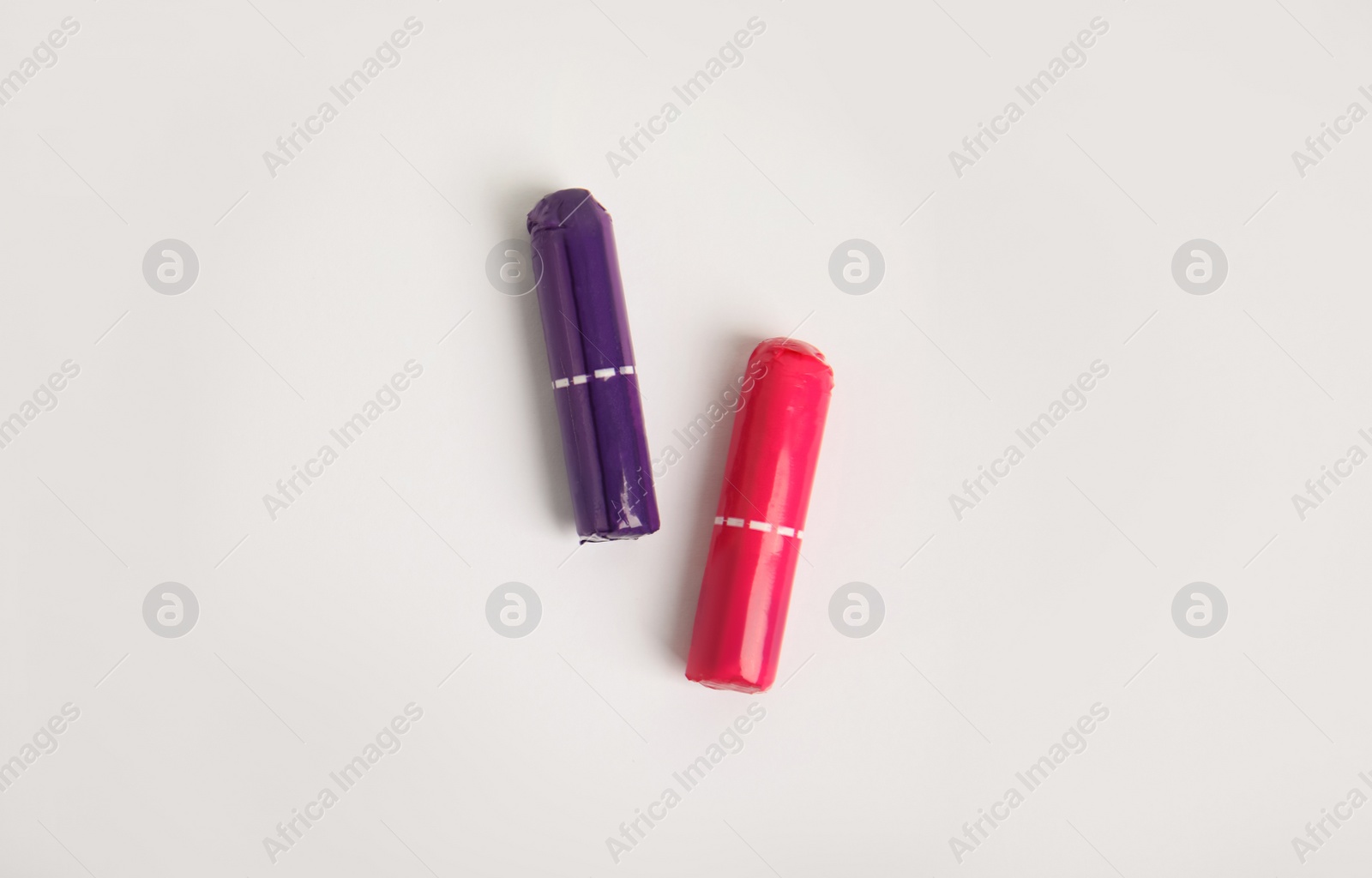 Photo of Two tampons on light background, flat lay