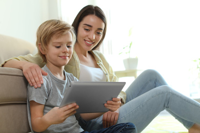 Photo of Mother and son reading E-book together at home