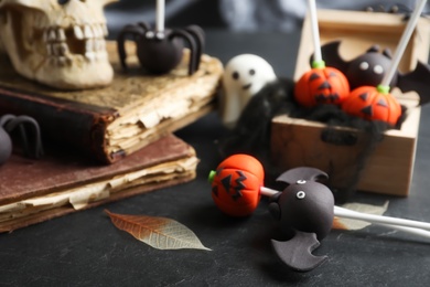 Different Halloween themed cake pops on black table