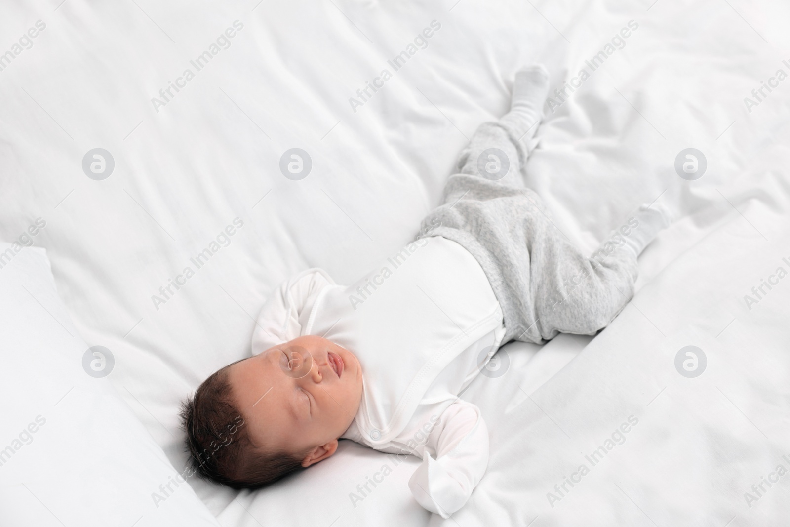 Photo of Cute newborn baby sleeping on white soft bed