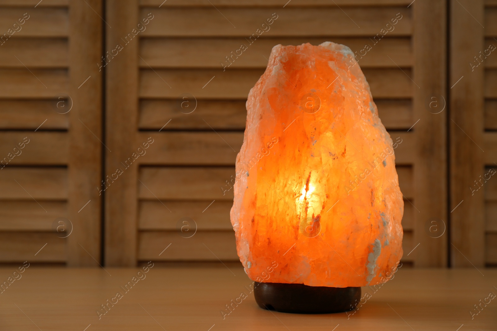 Photo of Himalayan salt lamp and space for text on wooden background