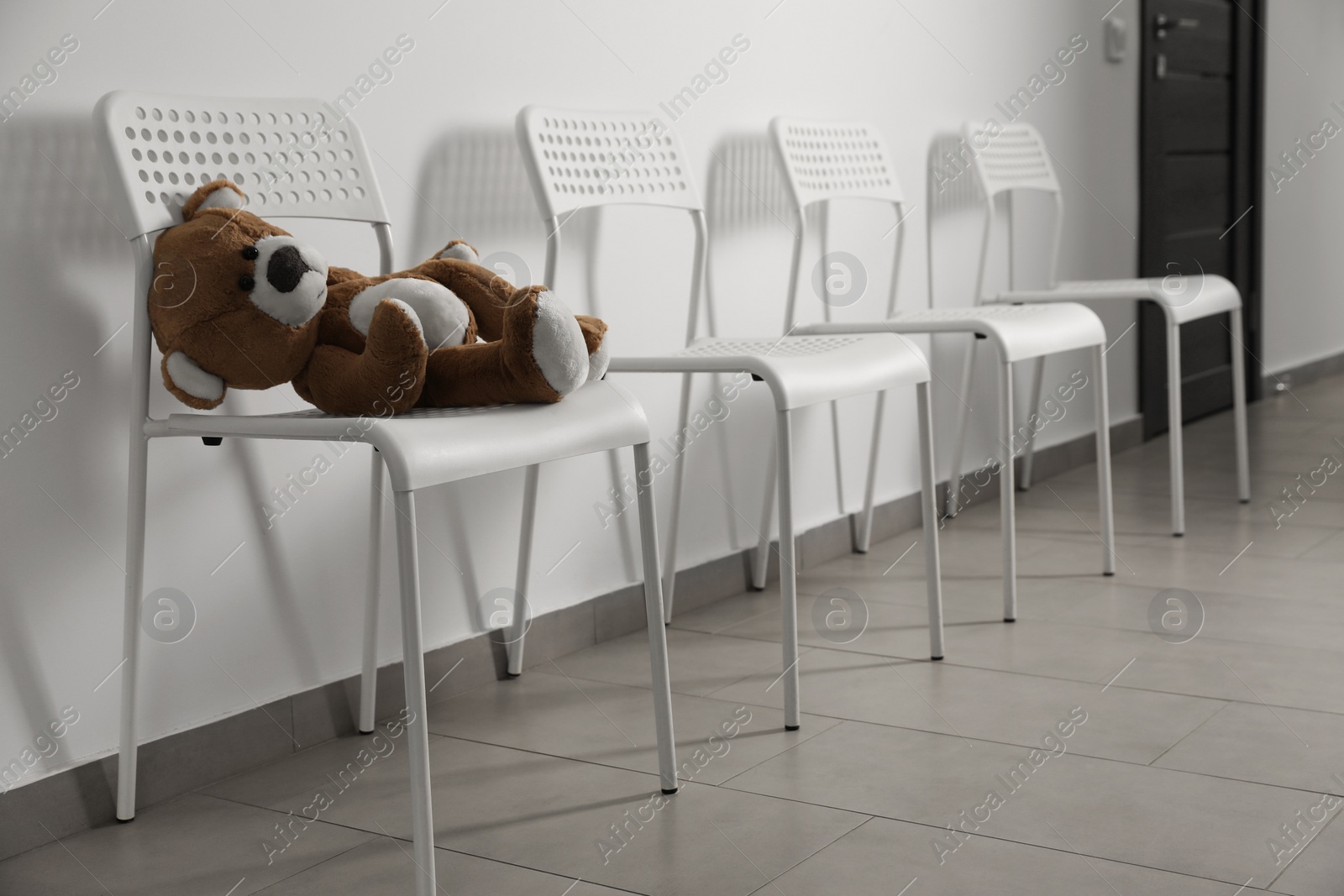 Photo of Cute teddy bear left on chair indoors. Space for text