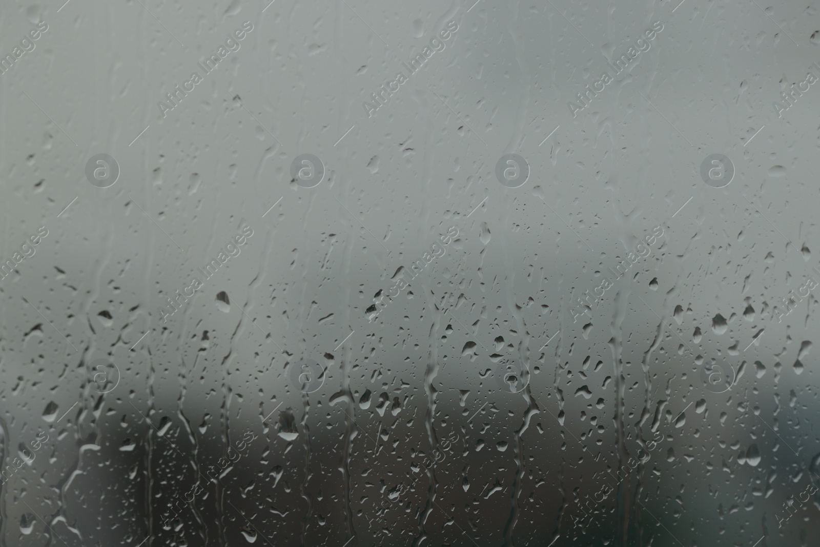 Photo of Window glass with water drops, closeup. Rainy weather