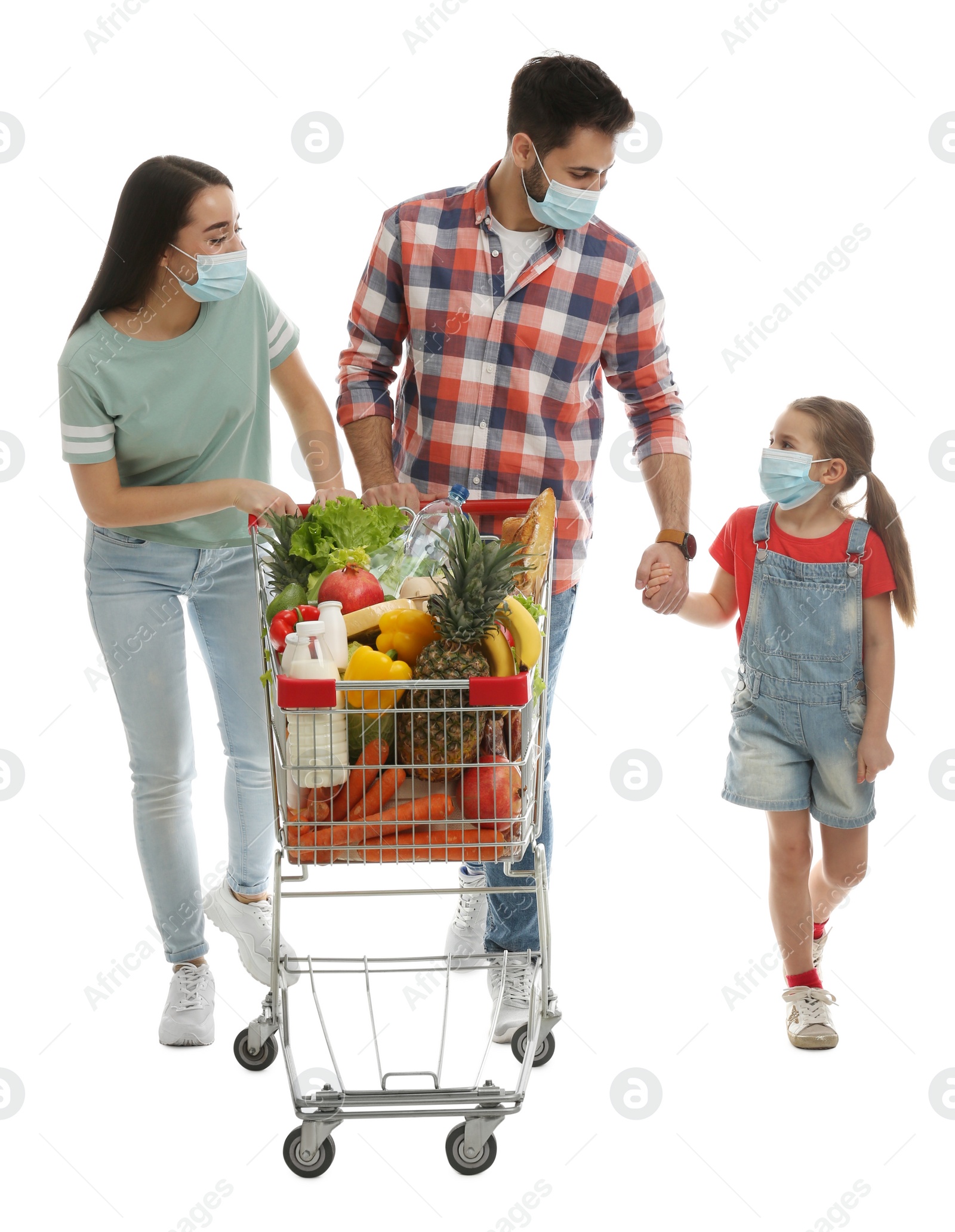 Photo of Family in medical masks with shopping cart full of groceries on white background