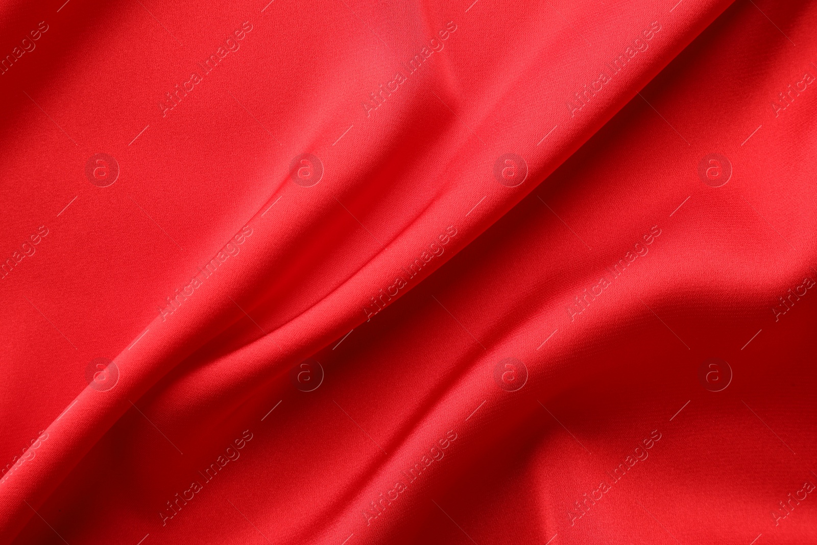 Photo of Crumpled red silk fabric as background, top view