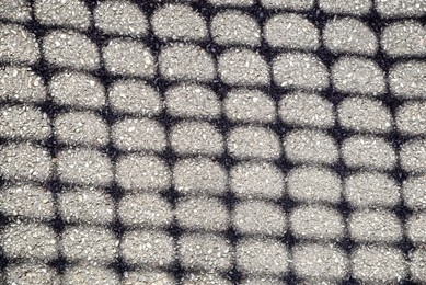 Photo of Pattern made with shadow of fence on asphalt