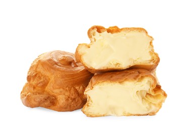 Photo of Cut and whole delicious profiteroles with cream filling on white background