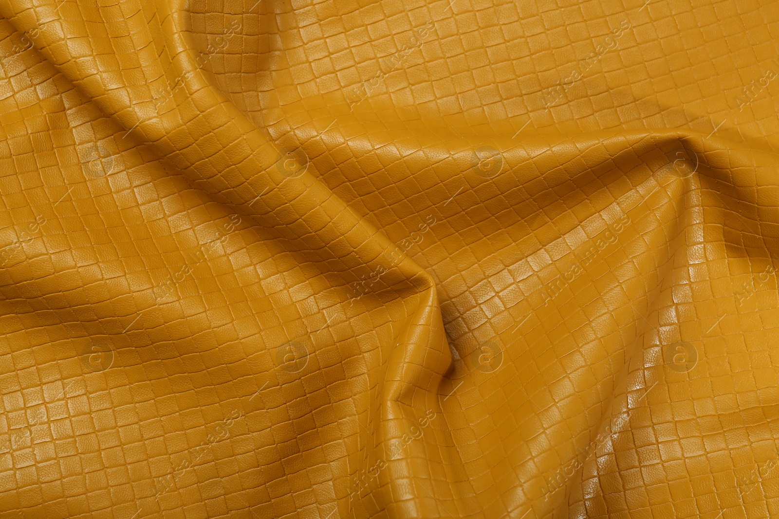 Photo of Beautiful yellow leather as background, top view