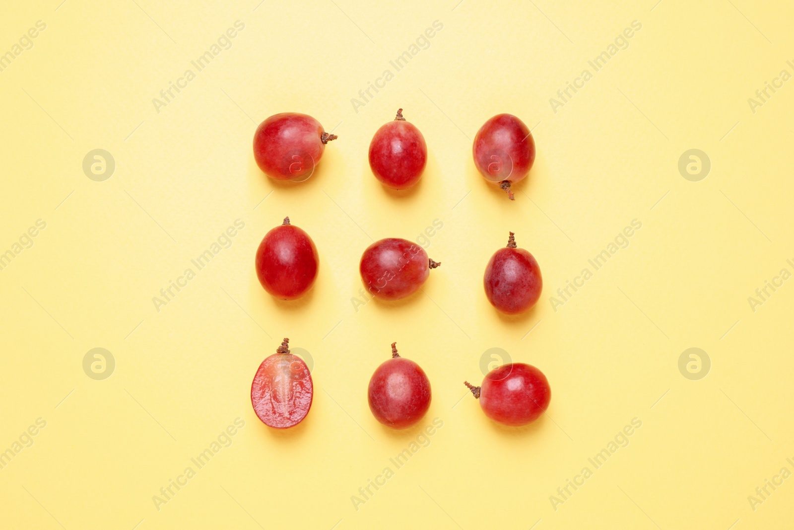 Photo of Flat lay composition with fresh ripe grapes on yellow background