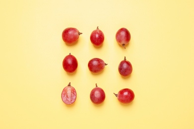 Flat lay composition with fresh ripe grapes on yellow background