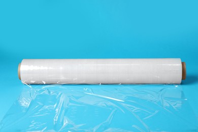 Photo of Roll of transparent stretch wrap on turquoise background