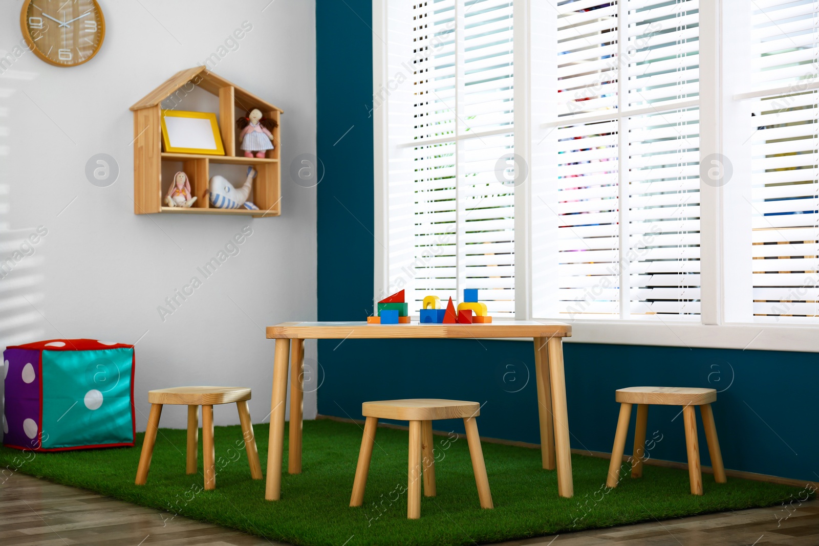 Photo of Stylish playroom interior with wooden table and stools