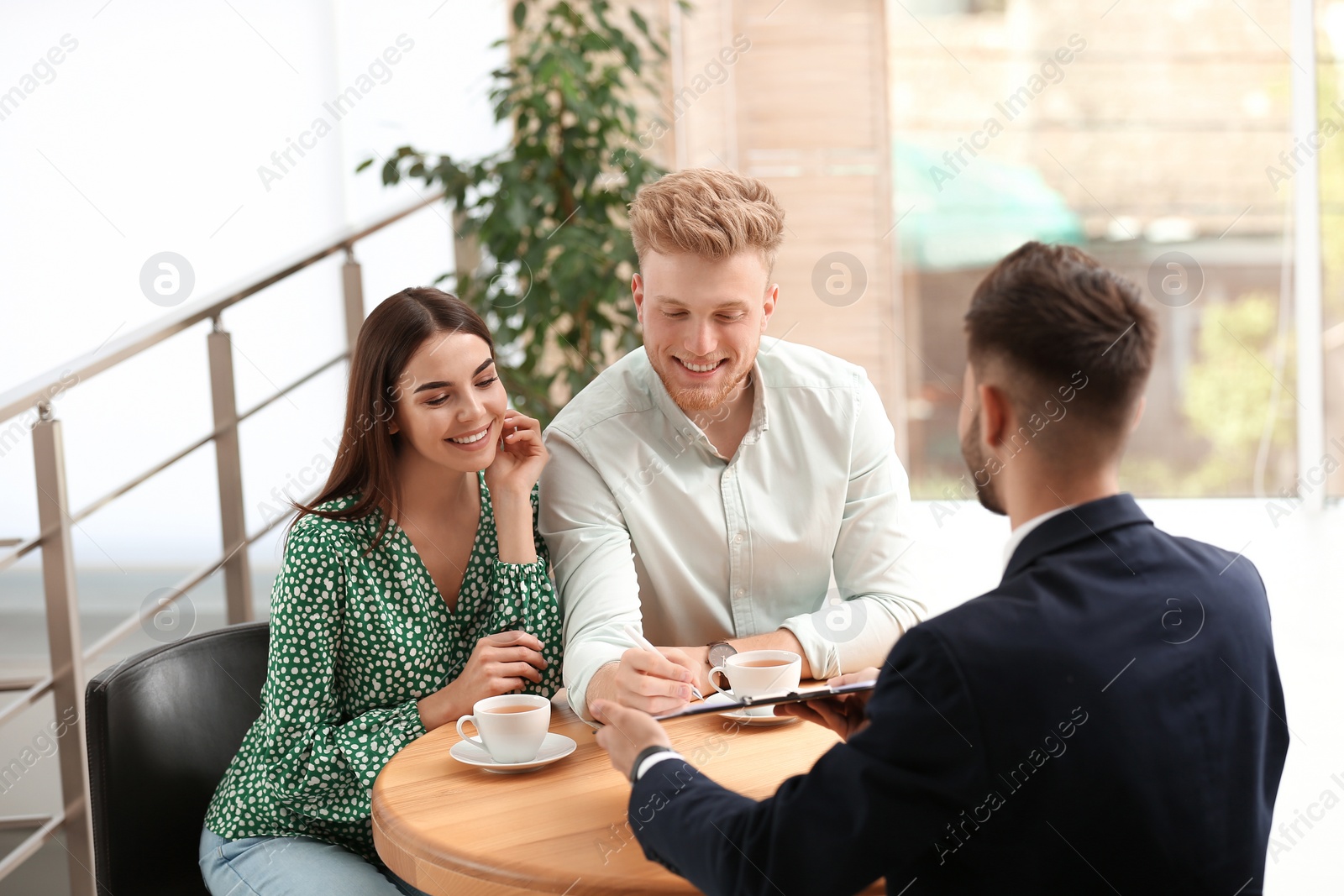 Photo of Insurance agent working with young couple in office