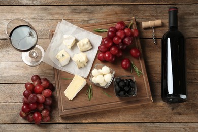 Flat lay composition with red wine and snacks on wooden table