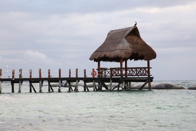 Photo of Wooden gazebo in sea on stormy weather