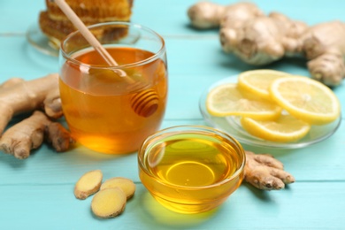 Photo of Honey, ginger and lemon on light blue wooden table. Natural cold remedies