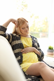 Beautiful pregnant woman resting on sofa at home