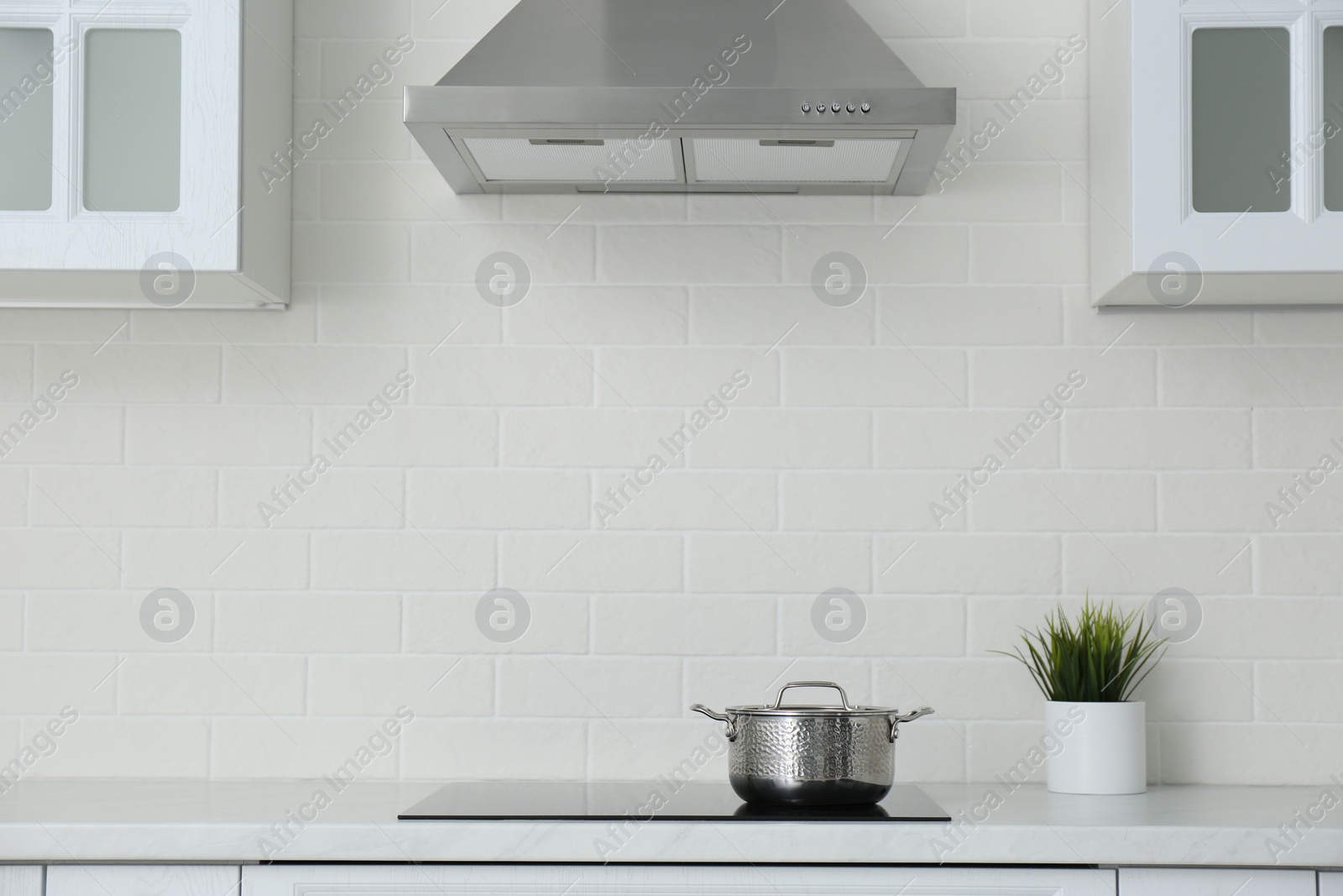 Photo of Saucepot on induction stove in stylish kitchen interior